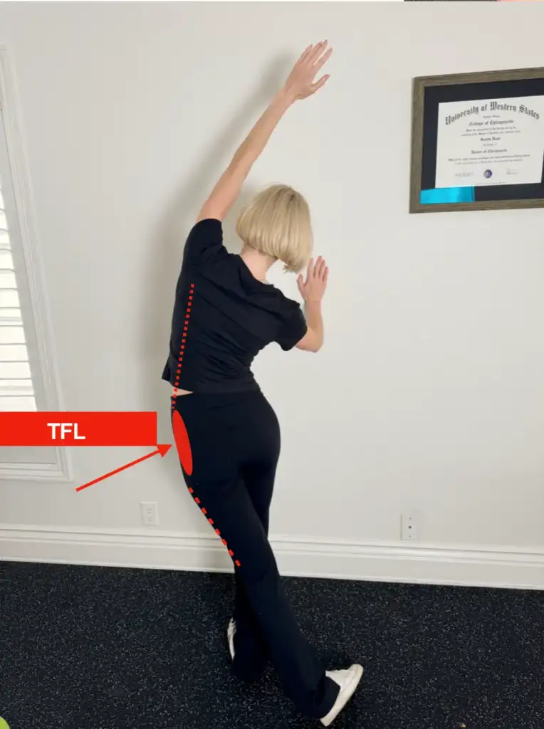 a Demostration of a standing version to stretch the iliotibial band. Step by step